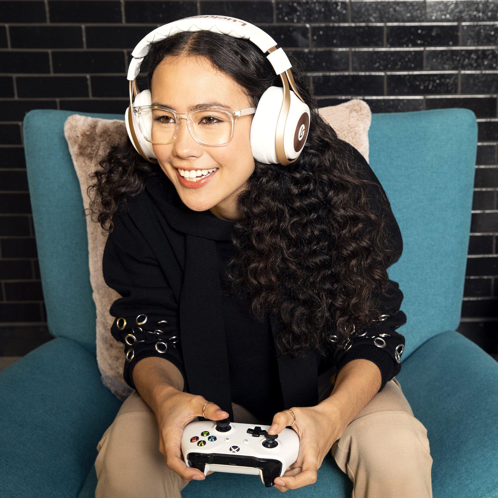 Girl in headphones plays a video game on the big TV screen. Gamer with a  joystick.